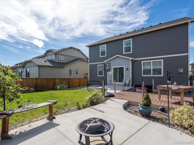 back of house with an outdoor fire pit, a yard, and a patio