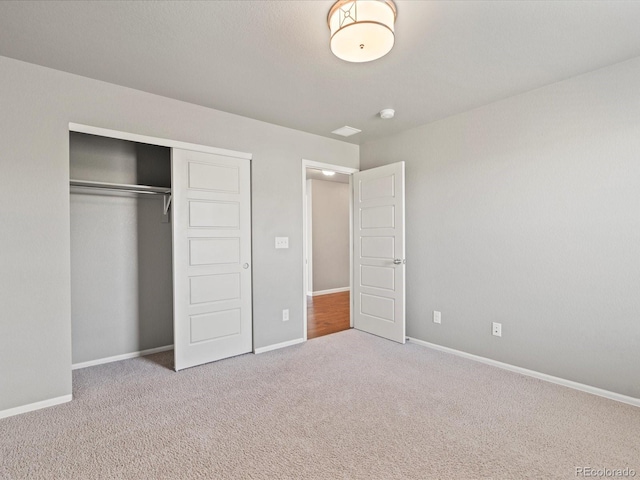 unfurnished bedroom featuring carpet, baseboards, and a closet