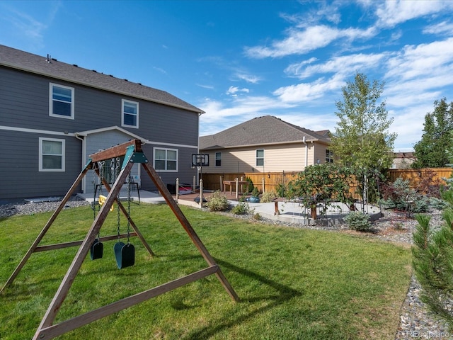 back of house featuring a patio, a yard, a playground, and fence