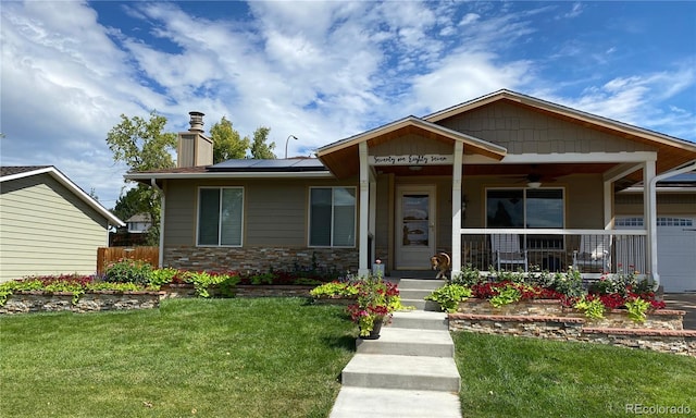 bungalow-style house featuring ceiling fan, a chimney, covered porch, roof mounted solar panels, and a front yard