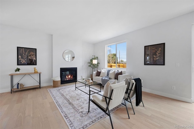 4018 Upham St, Wheat Ridge, CO 80033 - living room featuring light wood-style flooring, baseboards, and a glass covered fireplace