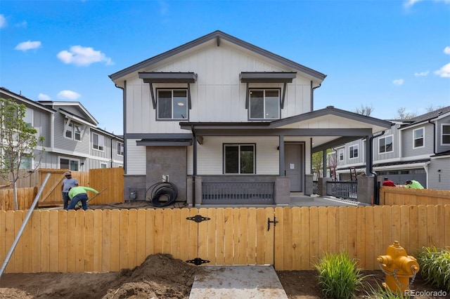 4018 Upham St, Wheat Ridge, CO 80033 - view of front facade featuring covered porch, a fenced front yard, a gate, and board and batten siding