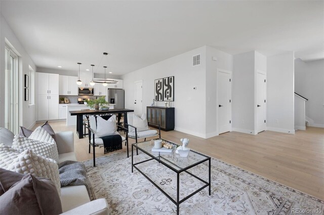 4018 Upham St, Wheat Ridge, CO 80033 - living room with light wood-style flooring, recessed lighting, baseboards, visible vents, and stairs