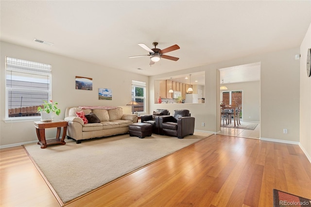 living room with ceiling fan, plenty of natural light, and hardwood / wood-style floors