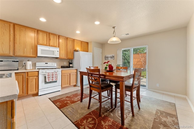 kitchen with white appliances, sink, hanging light fixtures, light tile patterned floors, and tasteful backsplash