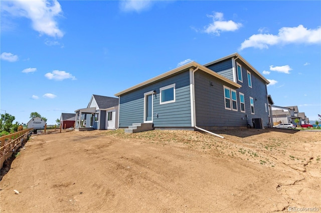 rear view of house featuring cooling unit and fence
