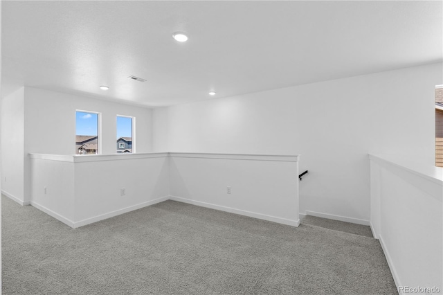 carpeted empty room featuring baseboards and recessed lighting