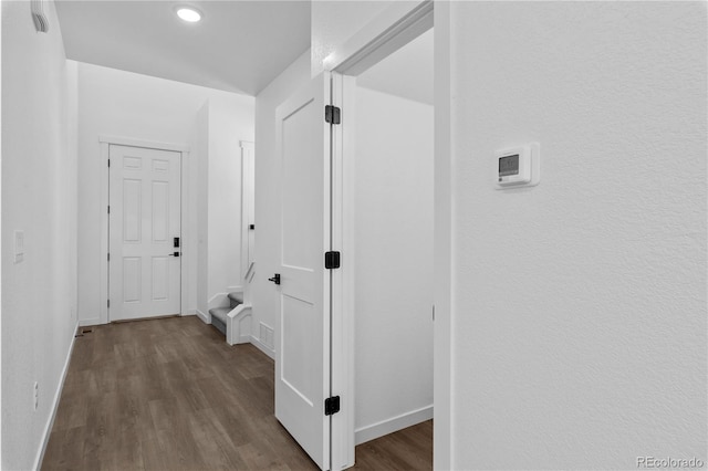 hallway featuring dark wood-style floors and baseboards
