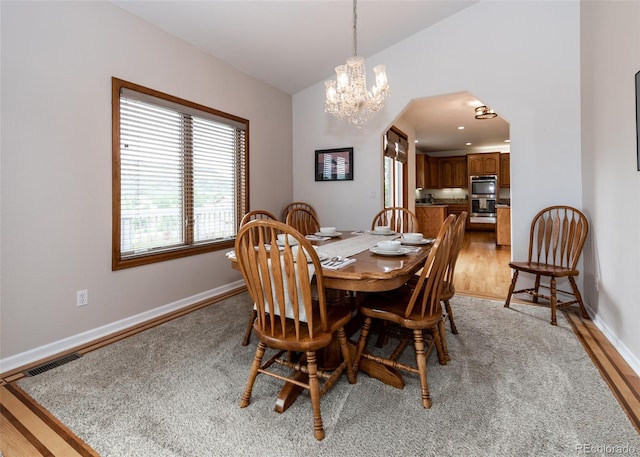 1660 Old Antlers Way, Monument, CO 80132 - dining room featuring a chandelier, light wood finished floors, and arched walkways