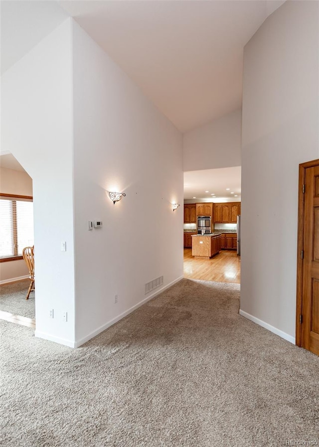 1660 Old Antlers Way, Monument, CO 80132 - unfurnished living room featuring light colored carpet, high vaulted ceiling, and recessed lighting
