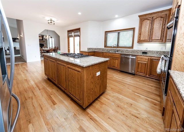 1660 Old Antlers Way, Monument, CO 80132 - kitchen with stainless steel appliances, a kitchen island, healthy amount of natural light, brown cabinets, and recessed lighting