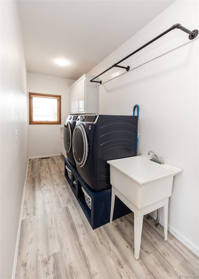 1660 Old Antlers Way, Monument, CO 80132 - laundry area featuring cabinet space, light wood-type flooring, and separate washer and dryer