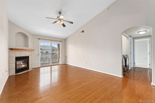 7440 S Blackhawk St Unit 7-303, Englewood, CO 80112 - unfurnished living room with ceiling fan, washer and clothes dryer, wood finished floors, vaulted ceiling, and arched walkways