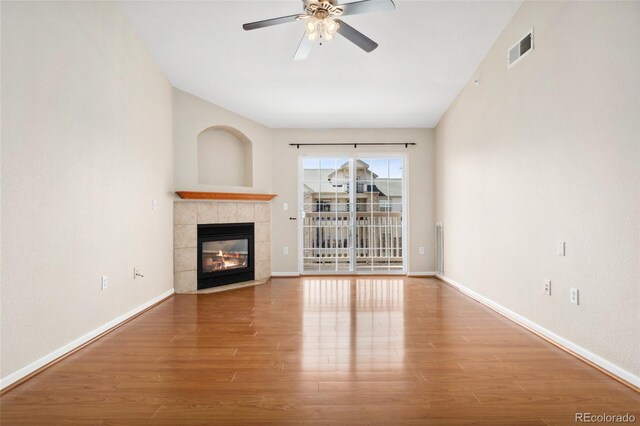 7440 S Blackhawk St Unit 7-303, Englewood, CO 80112 - unfurnished living room featuring wood finished floors, ceiling fan, a tile fireplace, and baseboards