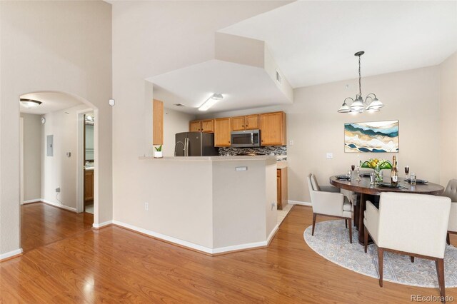 7440 S Blackhawk St Unit 7-303, Englewood, CO 80112 - kitchen with stainless steel appliances, light wood-style flooring, arched walkways, a chandelier, and pendant lighting