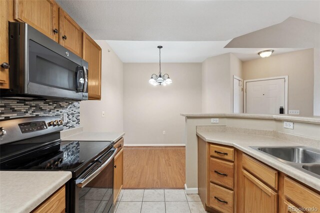 7440 S Blackhawk St Unit 7-303, Englewood, CO 80112 - kitchen featuring electric stove, black microwave, light countertops, decorative backsplash, and light tile patterned floors