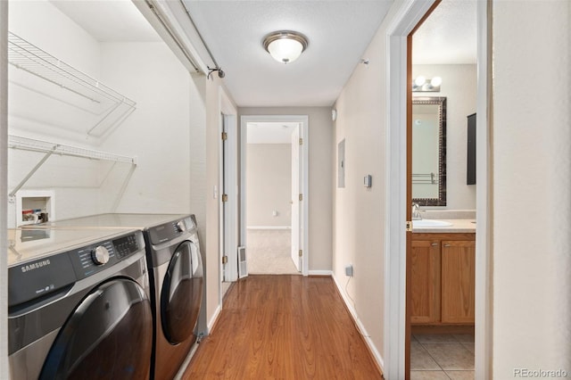 7440 S Blackhawk St Unit 7-303, Englewood, CO 80112 - washroom featuring independent washer and dryer, light wood finished floors, and baseboards
