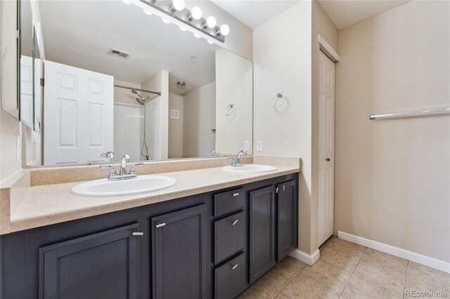 7440 S Blackhawk St Unit 7-303, Englewood, CO 80112 - bathroom featuring double vanity, tile patterned flooring, baseboards, and a shower