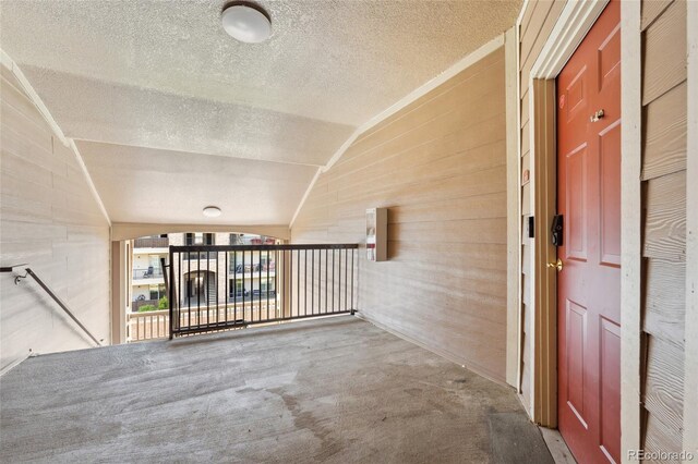 7440 S Blackhawk St Unit 7-303, Englewood, CO 80112 - hallway featuring vaulted ceiling, a textured ceiling, and carpet floors