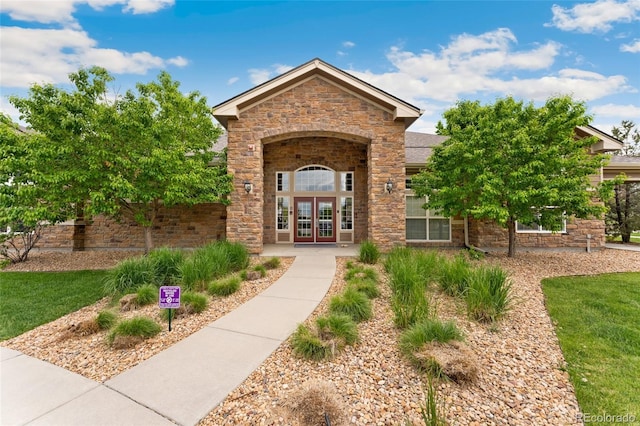 7440 S Blackhawk St Unit 7-303, Englewood, CO 80112 - property entrance with french doors, stone siding, and a shingled roof