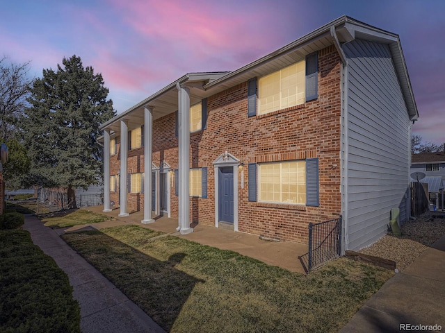 view of front of house featuring brick siding and a front yard