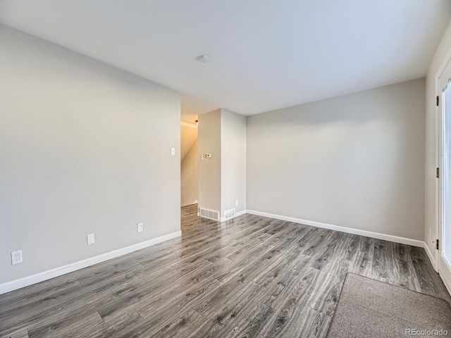 empty room with visible vents, baseboards, and wood finished floors