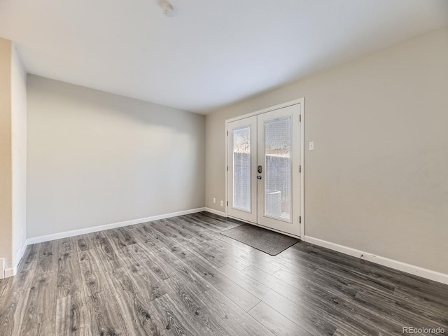 empty room with french doors, baseboards, and wood finished floors