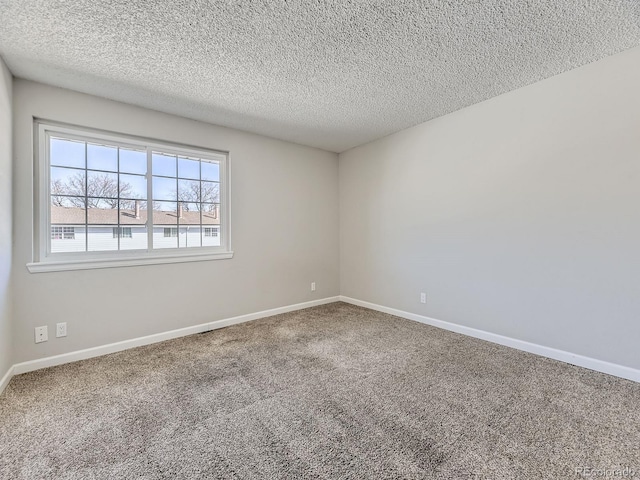 carpeted spare room with baseboards and a textured ceiling