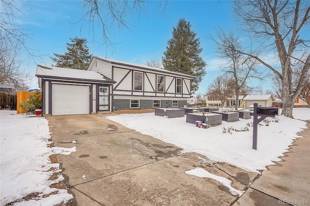 exterior space with a vegetable garden, driveway, an attached garage, and fence