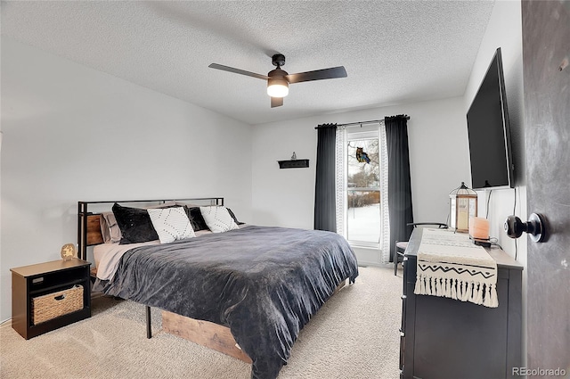 bedroom featuring light carpet, a textured ceiling, and a ceiling fan