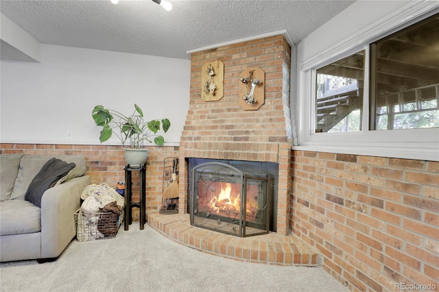 carpeted living area featuring a fireplace and a textured ceiling