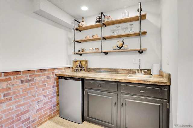 bar with brick wall, indoor wet bar, a sink, and freestanding refrigerator