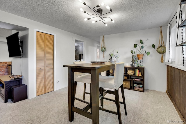 dining area with a textured ceiling and light colored carpet