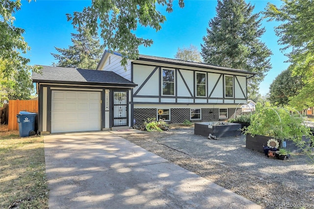 tudor-style house featuring a garage, driveway, a shingled roof, fence, and stucco siding