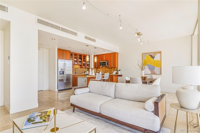 living area featuring light tile patterned floors, visible vents, and baseboards