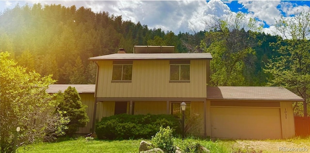 1037 Wagonwheel Gap Rd, Boulder, CO 80302 - view of front of property with a wooded view, a garage, and driveway