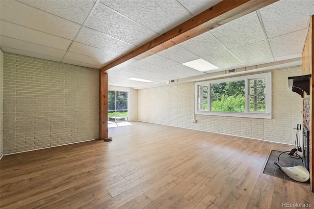 1037 Wagonwheel Gap Rd, Boulder, CO 80302 - unfurnished living room featuring brick wall, a drop ceiling, and hardwood / wood-style flooring