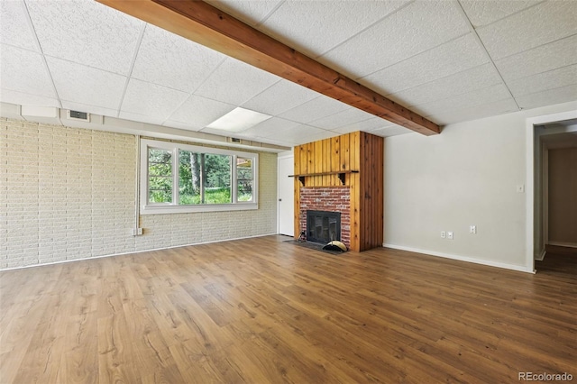 1037 Wagonwheel Gap Rd, Boulder, CO 80302 - unfurnished living room with wood finished floors, a fireplace, brick wall, baseboards, and beam ceiling