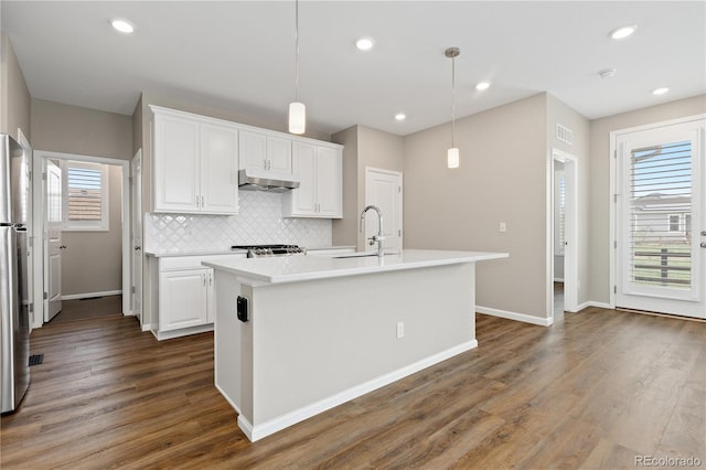27639 E 7th Ln, Aurora, CO 80018 - kitchen with under cabinet range hood, a sink, white cabinetry, decorative backsplash, and recessed lighting