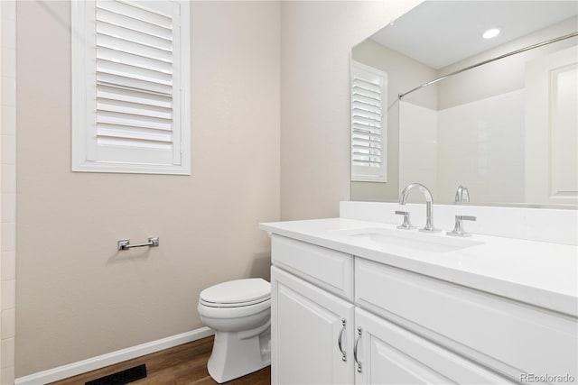 27639 E 7th Ln, Aurora, CO 80018 - bathroom featuring toilet, wood finished floors, vanity, baseboards, and a shower