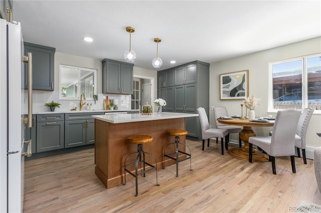1120 Hartford Dr, Boulder, CO 80305 - kitchen with light countertops, light wood-type flooring, a kitchen breakfast bar, recessed lighting, and freestanding refrigerator