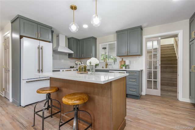 1120 Hartford Dr, Boulder, CO 80305 - kitchen with wall chimney range hood, high end fridge, light wood finished floors, and light countertops