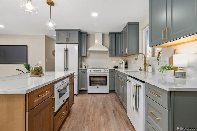 1120 Hartford Dr, Boulder, CO 80305 - kitchen with wall chimney exhaust hood, white appliances, light wood-style flooring, decorative light fixtures, and recessed lighting