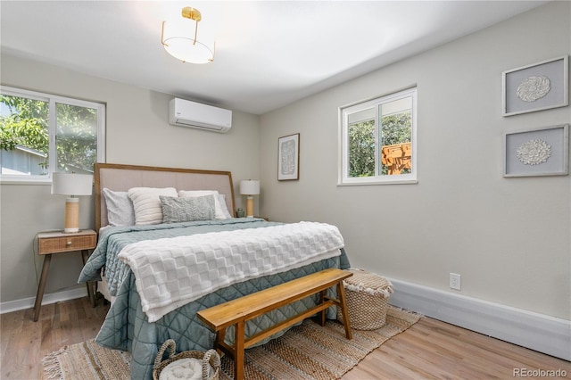 1120 Hartford Dr, Boulder, CO 80305 - bedroom featuring an AC wall unit, multiple windows, and wood finished floors