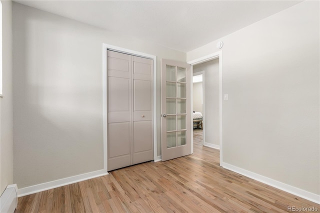 1120 Hartford Dr, Boulder, CO 80305 - unfurnished bedroom featuring a baseboard heating unit, wood finished floors, and a closet