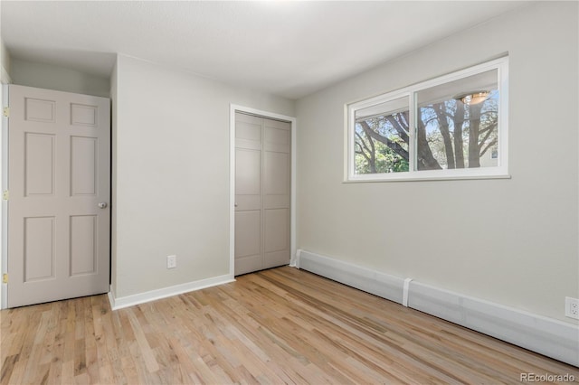 1120 Hartford Dr, Boulder, CO 80305 - unfurnished bedroom with light wood-type flooring, a closet, and a baseboard radiator