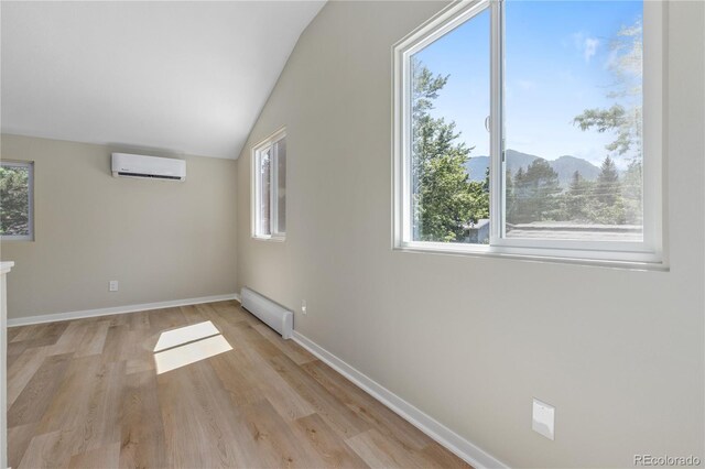 1120 Hartford Dr, Boulder, CO 80305 - spare room featuring a wall mounted air conditioner, healthy amount of natural light, a mountain view, light wood finished floors, and lofted ceiling