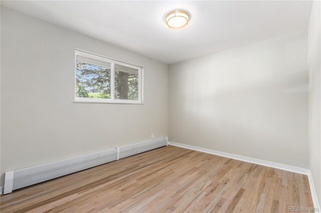 1120 Hartford Dr, Boulder, CO 80305 - spare room with light wood-type flooring and a baseboard radiator