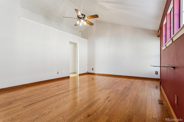 empty room with ceiling fan, high vaulted ceiling, and hardwood / wood-style floors