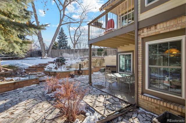 snow covered patio featuring a balcony